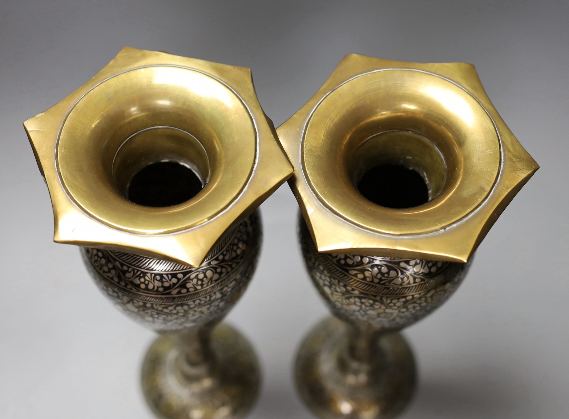 A pair of Indian damascened brass vases and a similar vase, pair of vases 33cms high